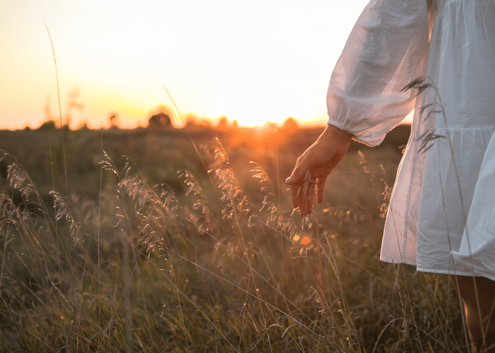 Woman walking through field thinking about self abandonment.